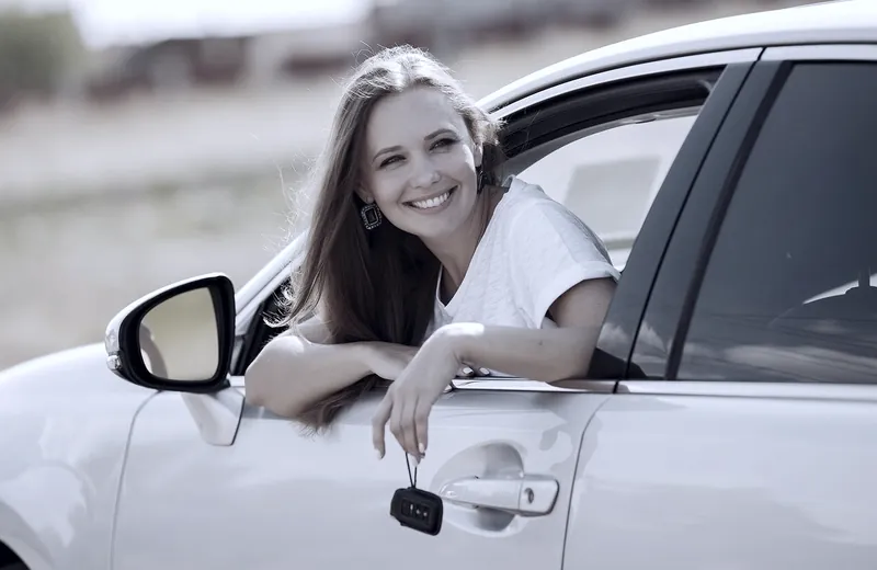 A driver holding the keys to a new car